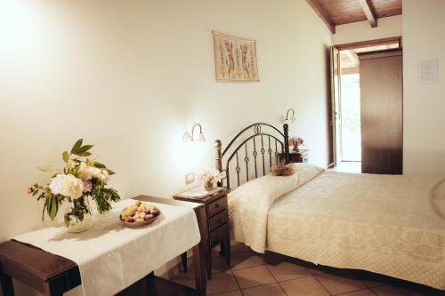 1 dormitorio con 2 camas y una mesa con flores en Su Leunaxiu, en Solèminis