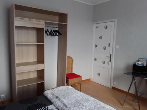 een kamer met een bed en een kast met planken bij Location Keransignour in Concarneau