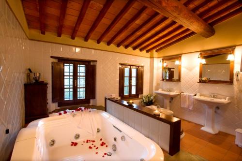 een grote badkamer met een groot bad en 2 wastafels bij Monsignor Della Casa Country Resort & Spa in Borgo San Lorenzo