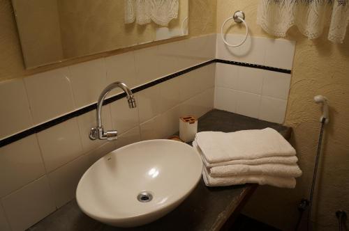 a bathroom with a sink and towels on a counter at Casa Caminho do Corcovado - Pet friendly in Rio de Janeiro