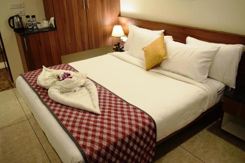 a hotel room with a bed with towels and flowers on it at Silicon Inn Hotel Bangalore Airport in Devanahalli-Bangalore