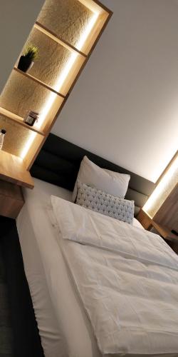 a bedroom with a white bed with a light above it at Hotel Nachtquartier in Weil der Stadt