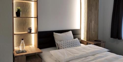 a bedroom with a bed and a bottle of water at Hotel Nachtquartier in Weil der Stadt
