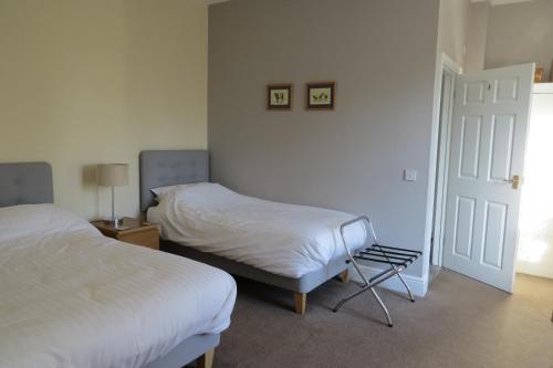 a bedroom with two beds and a door with a window at Furtho Manor Farm in Milton Keynes