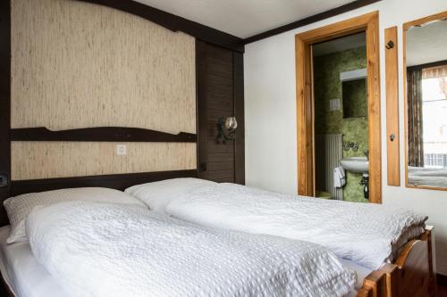 a bedroom with a large bed with a wooden headboard at Hotel Burgener in Saas-Fee