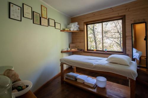 Habitación pequeña con cama y ventana en Parque Amavida, en Malalcahuello