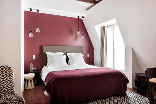 a bedroom with red walls and a bed with white pillows at New Hotel Le Voltaire in Paris