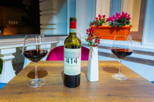 two glasses of red wine on a wooden table at ART Hotel Tirana in Tirana