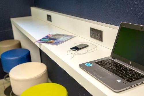 a laptop computer sitting on top of a counter at ibis budget Vienne Sud in Vienne