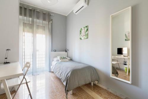 een slaapkamer met een bed, een bureau en een spiegel bij Enjoy Porta Furba in Rome