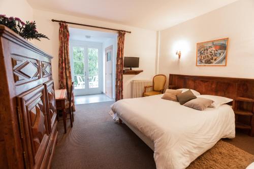 a bedroom with a bed and a desk and a window at Chez Bouchet in Licq-Athérey