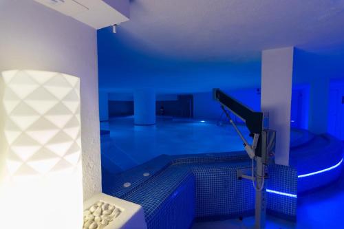 a blue room with a swimming pool and a telescope at R2 Bahia Cala Ratjada - Adults Only in Cala Ratjada