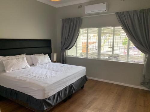 um quarto com uma cama grande e uma janela em Stern self catering apartments em Windhoek