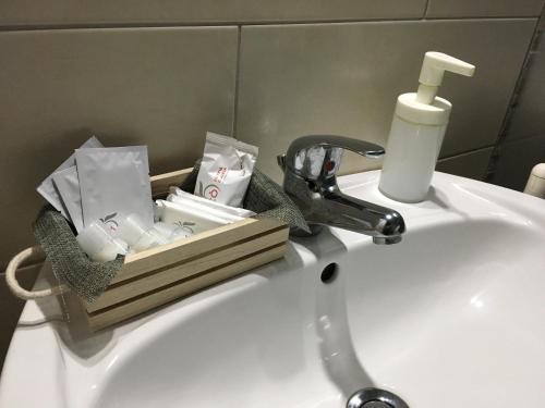 un lavandino in bagno con una scatola di sapone e un rubinetto di Camere Con Terrazzino a Valderice