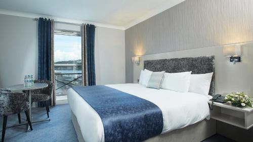 ウォーターフォードにあるTower Hotel & Leisure Centreの大きなベッドと窓が備わるホテルルームです。