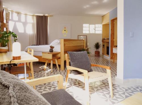 Una sala de estar con una cama, una mesa y sillas. en Casa Nuevo Leon, en Ciudad de México