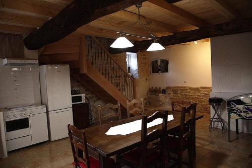 - une cuisine et une salle à manger avec une table et des appareils en bois dans l'établissement Le Bouquet de Soizic, à Grandjean