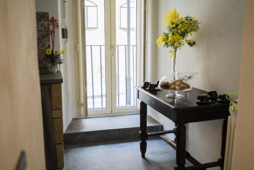 a table with a vase of flowers on it next to a window at Due Residenze da Giò in Noto