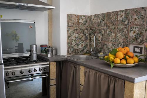 a kitchen with a bowl of fruit on a counter at Due Residenze da Giò in Noto