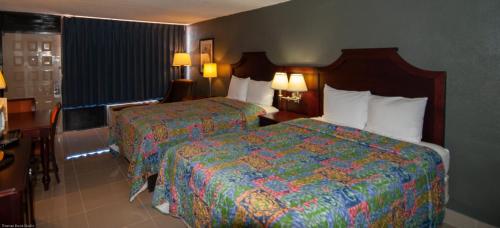 a hotel room with two beds and a desk at Express Inn & Suites - 5 Miles from St Petersburg Clearwater Airport in Clearwater