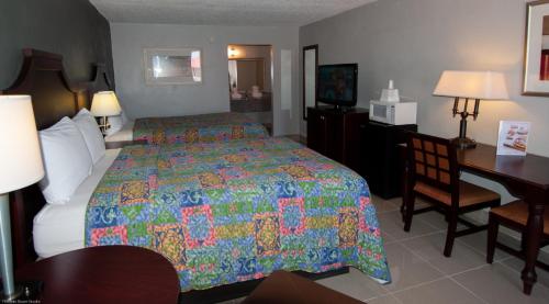 a hotel room with a large bed and a desk at Express Inn & Suites - 5 Miles from St Petersburg Clearwater Airport in Clearwater