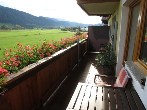 a balcony with flowers and a bench on a house at Haus Wiesenrain in Radstadt