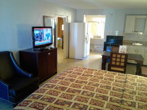 a room with a bed and a television and a kitchen at Express Inn & Suites - 5 Miles from St Petersburg Clearwater Airport in Clearwater