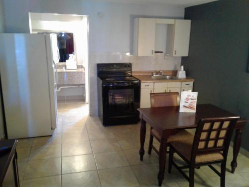 a kitchen with a table and a stove and a refrigerator at Express Inn & Suites - 5 Miles from St Petersburg Clearwater Airport in Clearwater