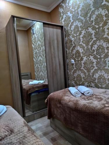 a hotel room with two beds and a mirror at My House in Akhaltsikhe in Akhaltsikhe