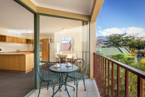 a patio with a table and chairs on a balcony at Quest Trinity House in Hobart