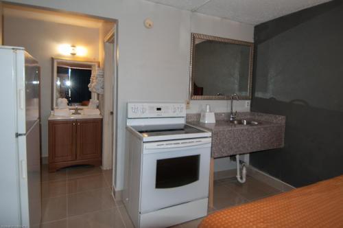 a kitchen with a white stove and a sink at Express Inn & Suites - 5 Miles from St Petersburg Clearwater Airport in Clearwater