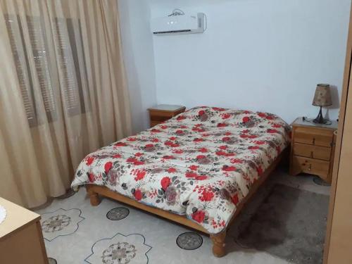 1 Schlafzimmer mit einem Bett mit Blumendecke in der Unterkunft Beltaief Residence in Houmt Souk