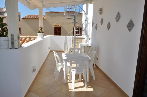 a table and chairs on the balcony of a house at Casa Bianca Del Centro in San Vito lo Capo