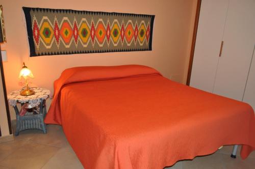 a bedroom with a red bed and a table at Casa Bianca Del Centro in San Vito lo Capo
