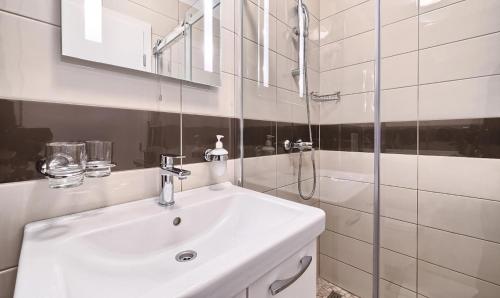 a white bathroom with a sink and a shower at Stipe Residence in Podstrana