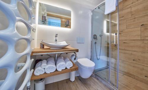 ein Bad mit einem Waschbecken, einem WC und einer Dusche in der Unterkunft Saalbacher Perle Top 4 in Saalbach-Hinterglemm