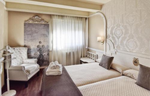 a bedroom with a bed and a couch and a chair at Hotel Maria Luisa in Burgos