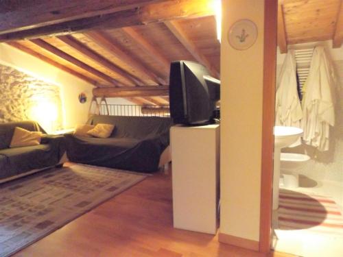ein Wohnzimmer mit einem TV und einem Sofa in der Unterkunft Casa Canevini in Garda