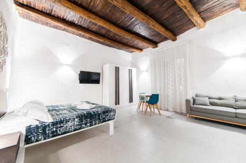 a white bedroom with a bed and a couch at Dada Suite in Naples