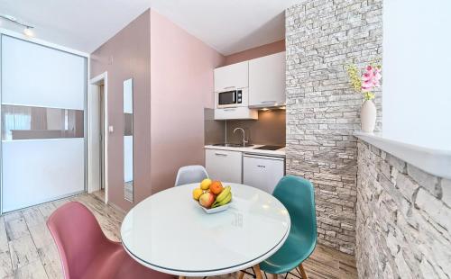 a small kitchen with a white table and chairs at Stipe Residence in Podstrana