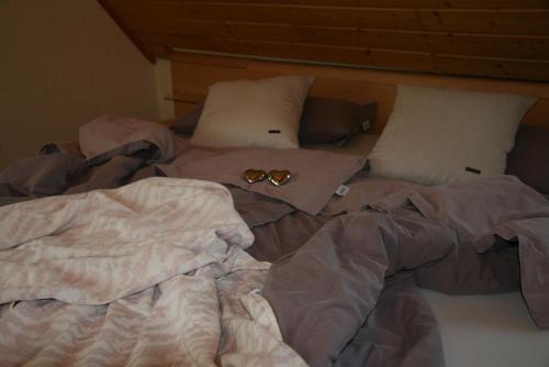 an unmade bed with two pairs of glasses on it at Ferienwohnung Dieter Popp in Münchberg