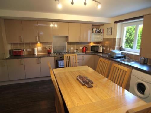 a large kitchen with a wooden table and a tableablish at Allanfield Townhouse in Edinburgh