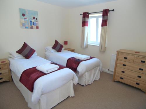 - une chambre avec 2 lits, une commode et une fenêtre dans l'établissement Allanfield Townhouse, à Édimbourg