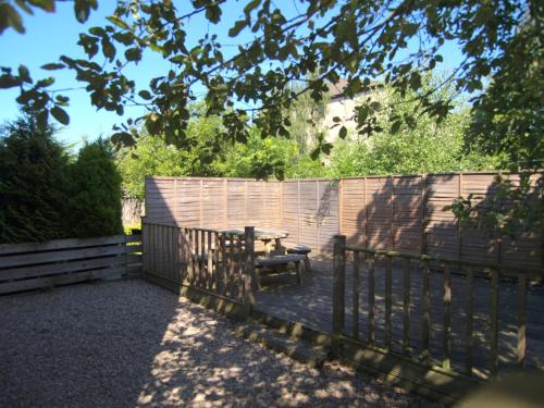 a wooden fence with a wooden table and a bench at Allanfield Townhouse in Edinburgh