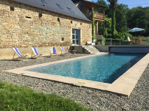 une piscine avec des chaises et une maison dans l'établissement Maison D'Orride, à Ledeuix