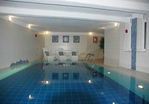 una piscina cubierta con suelo de baldosa azul en Ferienwohnungen Traumlage en Kronsgaard