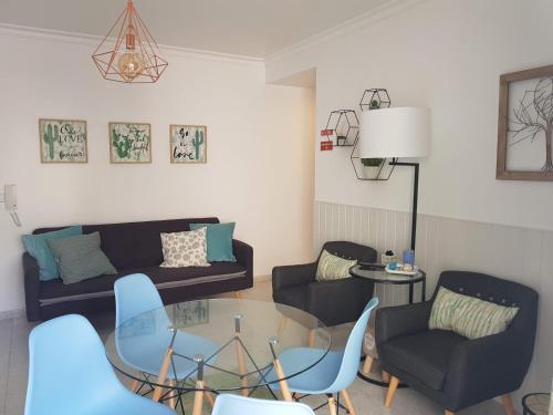 a living room with a glass table and chairs at Apartamento Monte Gordo in Monte Gordo
