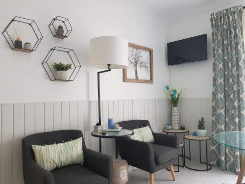 a living room with two chairs and a table at Apartamento Monte Gordo in Monte Gordo