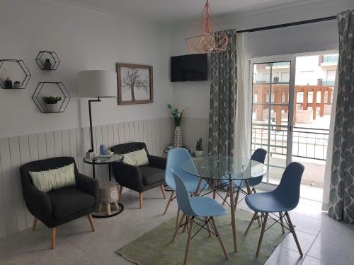a dining room with a glass table and chairs at Apartamento Monte Gordo in Monte Gordo