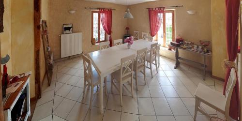 una sala da pranzo con tavolo e sedie bianchi di Le Gros Chêne, Lac du Der a Frampas